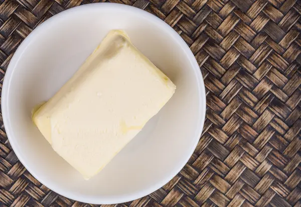 Bloco Manteiga Tigela Branca Sobre Fundo Vime — Fotografia de Stock