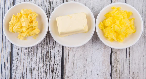 Bloque Mantequilla Margarina Ghee Cuencos Blancos Sobre Fondo Rústico Madera — Foto de Stock