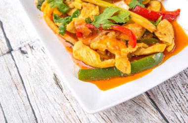 Ayam Paprik veya baharatlı stir fry tavuk ahşap arka plan üzerinde beyaz tabakta Malezya geleneksel çanak