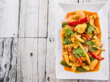 Ayam Paprik veya baharatlı stir fry tavuk ahşap arka plan üzerinde beyaz tabakta Malezya geleneksel çanak