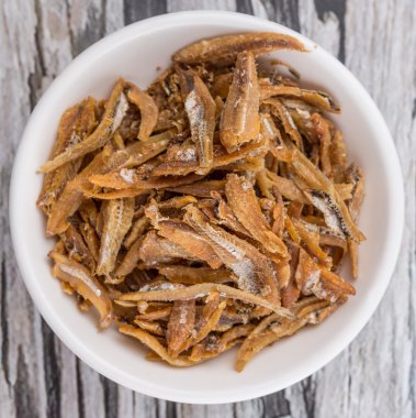 Derin kızarmış hamsi rustik wiccker arka plan üzerinde beyaz kase