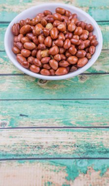 Derin kızarmış fıstık rustik ahşap arka plan üzerinde beyaz kase