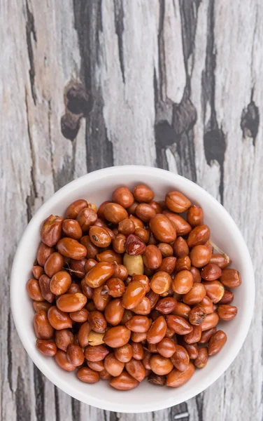 Kacang Goreng Dalam Mangkuk Putih Atas Latar Belakang Kayu Berkarat — Stok Foto