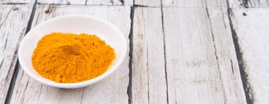 Zerdeçal tozu rustik ahşap arka plan üzerinde beyaz kase