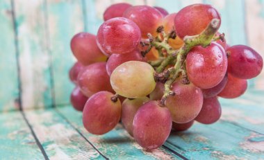 Ahşap arka plan üzerinde kırmızı üzüm demet