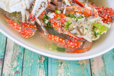 Malezya çanak açık yengeç çorbası ahşap arka plan üzerinde beyaz bir kase