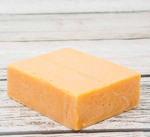 Un bloque de queso cheddar —  Fotos de Stock