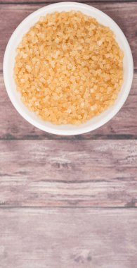 Kahverengi şeker ahşap arka plan üzerinde beyaz kase