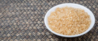 Kahverengi şeker ahşap arka plan üzerinde beyaz kase