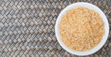 Kahverengi şeker ahşap arka plan üzerinde beyaz kase