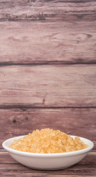 Azúcar moreno en tazón blanco sobre fondo de madera — Foto de Stock