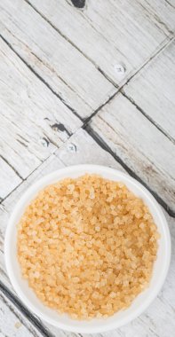 Kahverengi şeker ahşap arka plan üzerinde beyaz kase