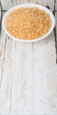 Kahverengi şeker ahşap arka plan üzerinde beyaz kase