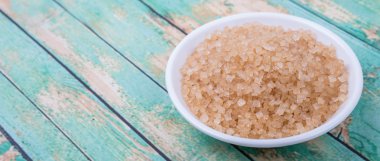 Kahverengi şeker ahşap arka plan üzerinde beyaz kase