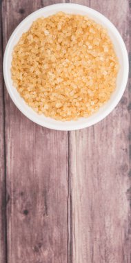 Kahverengi şeker ahşap arka plan üzerinde beyaz kase