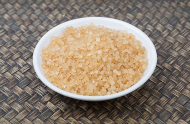 Kahverengi şeker ahşap arka plan üzerinde beyaz kase