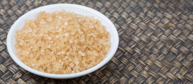 Kahverengi şeker ahşap arka plan üzerinde beyaz kase