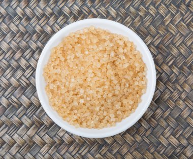 Kahverengi şeker ahşap arka plan üzerinde beyaz kase