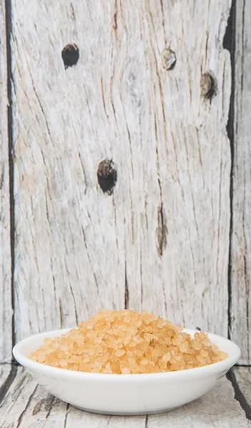 Brązowy cukier w misce biały na tle drewniane — Zdjęcie stockowe