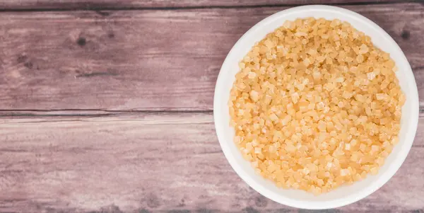 Zucchero di canna in ciotola bianca su fondo di legno — Foto Stock