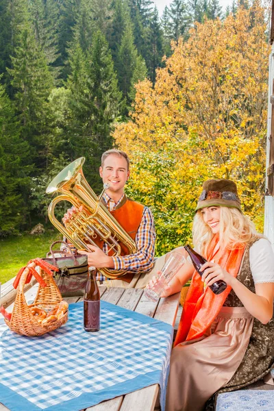 Casal jovem em traje tradicional bávaro na festa em um pasto de verão nas montanhas — Fotografia de Stock