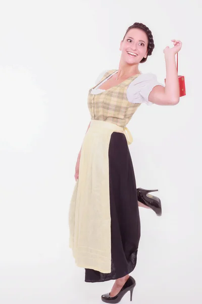 Young Bavarian woman in dirndl holds a small packet with a finger over the shoulder — Stock Photo, Image