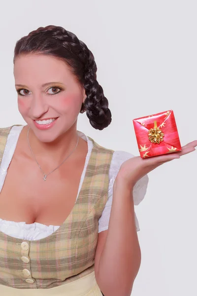 Junge Bayerin im Dirndl mit kleinem Geschenk auf der Handfläche. — Stockfoto