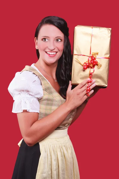 Młoda kobieta z dirndl i wielki dar w ręku — Zdjęcie stockowe