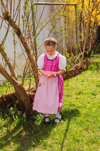 Menina no dirndl está entediado com os coloridos oscilam na mão — Fotografia de Stock