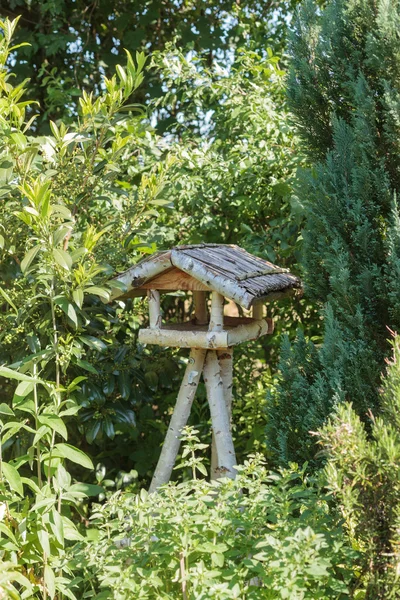 Three-legged wooden bird table — Stockfoto