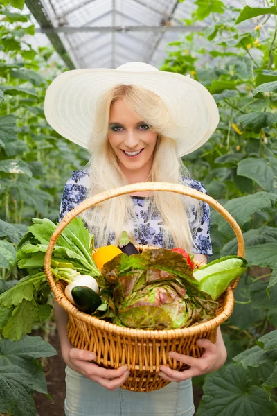 Aantrekkelijke blonde vrouw met een mandje met groenten — Stockfoto