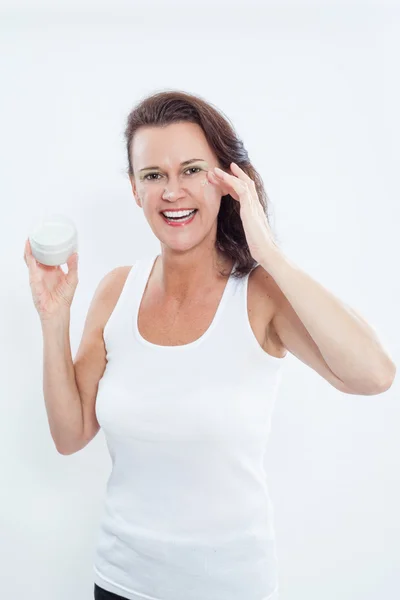 Brunette Woman Applying Eye Cream to Face — Stock Fotó