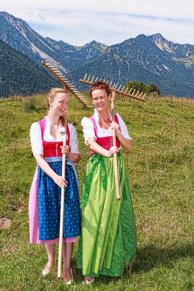 Due donne in dirndl con rastrelli si divertono al lavoro — Foto Stock
