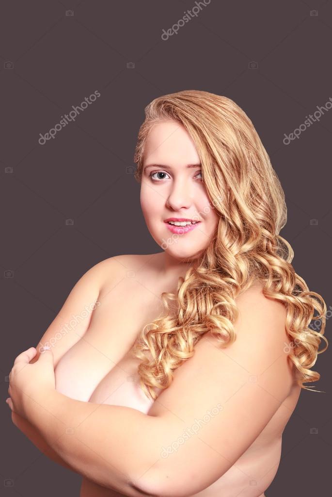 Young plump woman hides her naked breasts with arms Stock Photo by  Â©STphotography 89077368