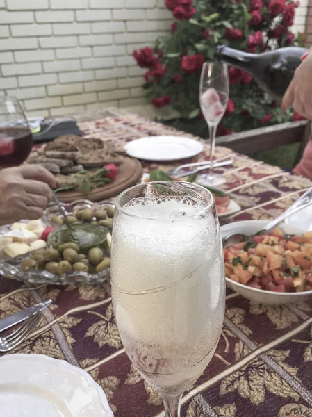Sektgläser und Essen auf dem Tisch im Garten — Stockfoto