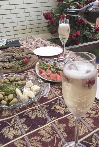 Champagne glasses and appetisers on table — Stock Photo, Image