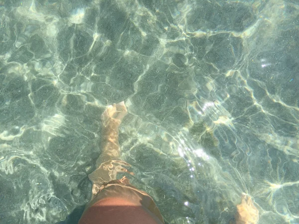 Füße und Beine einer Frau unter Wasser / Meer — Stockfoto
