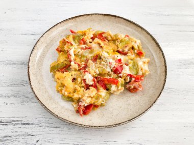 Kahvaltı için tabağında taze biber ve domates olan omlet.