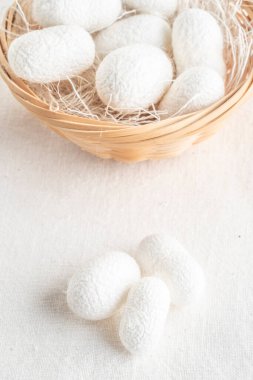 Beyaz ipek böceği kozaları, sepetteki ipek kumaş kaynağı.