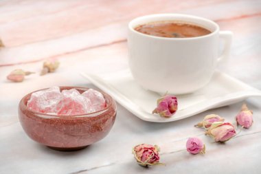 Türk lokumu ve kahve, gül çiçekleriyle süslenmiş masanın üstünde.