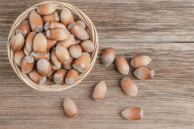 Fındıklı fındıklı ve fındıklı bir sepet içinde ahşap bir masada.