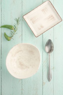 Boş, temiz kase ve tabağı kopyalama alanı olan yeşil ahşap bir masaya koyun.