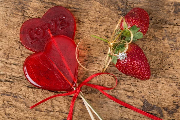 Anillo de diamantes, caramelos en forma de corazón y fresas — Foto de Stock