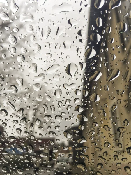 Gocce di pioggia sulla finestra sopra gli edifici — Foto Stock