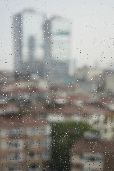 Regentropfen auf Fenster gegen Wohnungen — Stockfoto