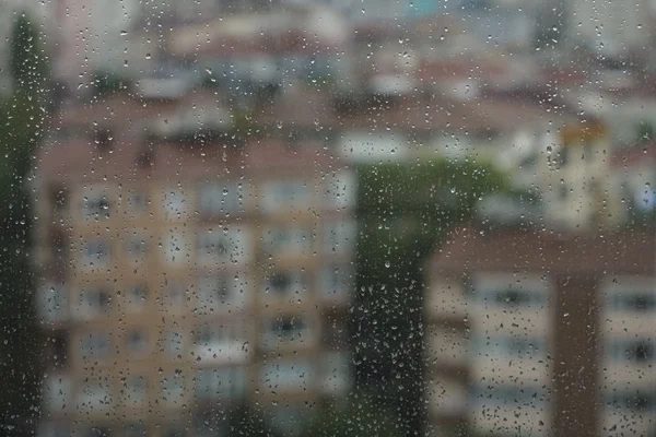 Gotas de lluvia en la ventana contra apartamentos — Foto de Stock