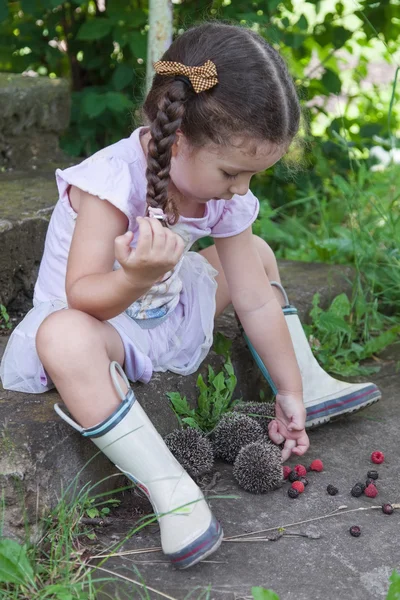 Bébé fille joue avec les hérissons — Photo