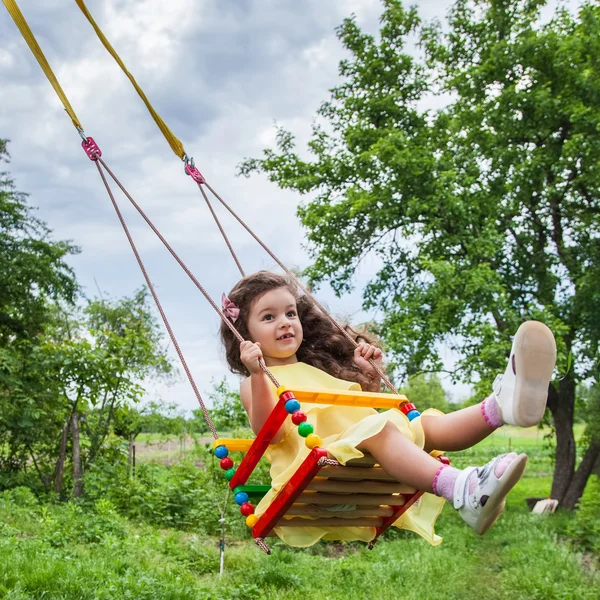 Bebé niña en swing al aire libre — Foto de Stock