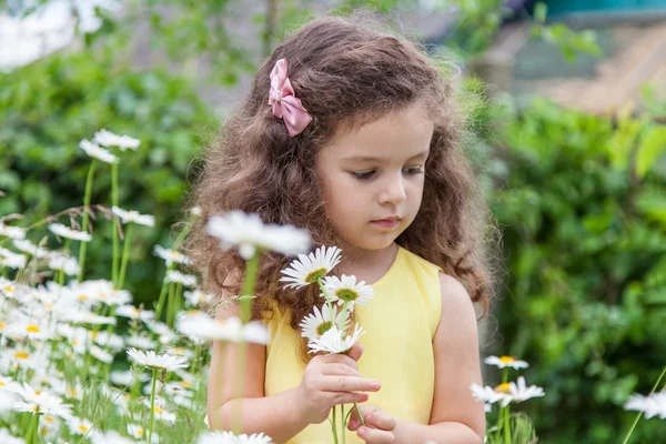 Bébé fille avec des marguerites à l'extérieur — Photo