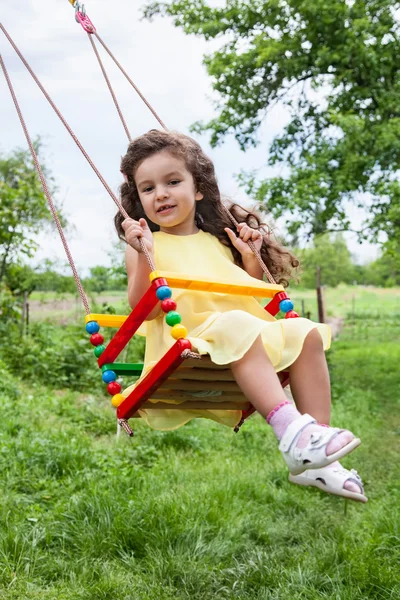 Bebé niña en swing al aire libre — Foto de Stock